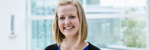 Woman smiling in blue top on University campus