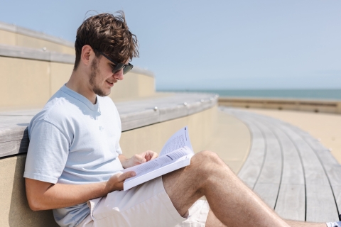 Student reading on the beach 