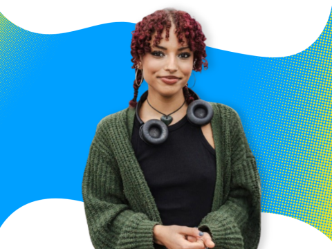 A student smiling in front of a blue background