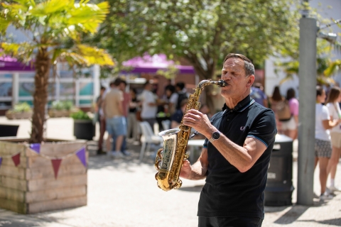 Man playing saxophone outside in the sunshine