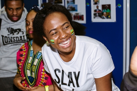 Student smiling, she has Tanzanian flags painted on her cheeks