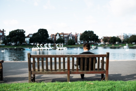 A person sat on a bench looking at Canoe Lake
