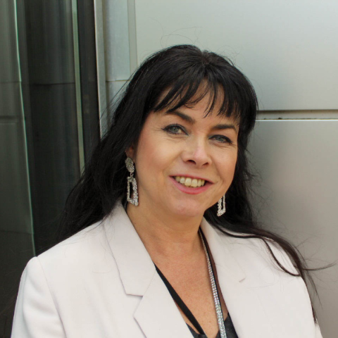 Picture of a woman with black hair smiling and standing outside the Careers and Employability Centre