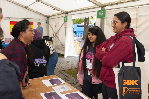 Three people standing around a stall