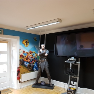 Statue of video game character and shelf of video game consoles in Five by Five break room