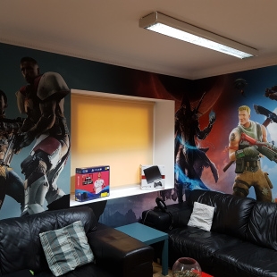 The Five by Five break room with black sofas and walls painted with video game characters