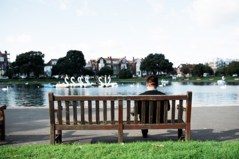 A person sat on a bench looking at Canoe Lake