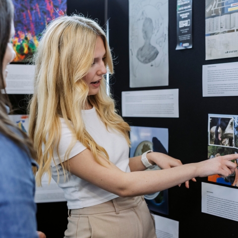Photo of Laura Saunders presenting information at stall.- Festival of Doctoral ResearchFOR GRADUATE SCHOOL USE ONLY