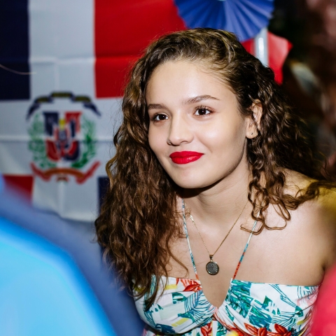 Female student smiling and talking to others at Festival of Cultures