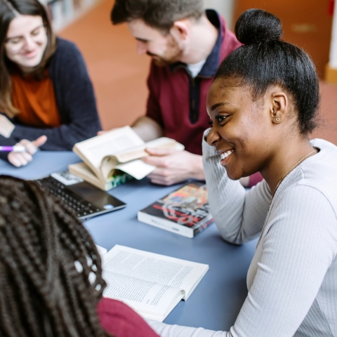 Students in library smiling in group study