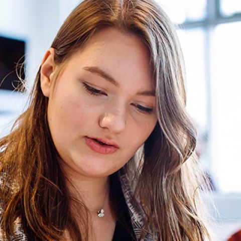 Female student in blazer reading notes