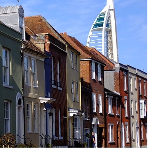 Row of coloured houses on street with the spinnaker tower just visible in the backgroun