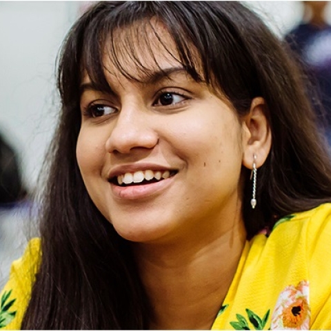 Student wearing yellow top and chatting.