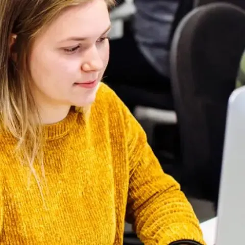 Students in computer suite in yellow jumper