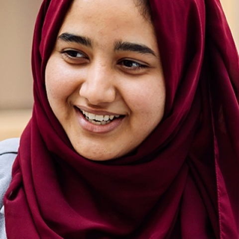 Student in hijab has a conversation with peer at research conference