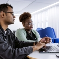 Two students looking at a laptop