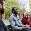 Three students sat on bench relaxing