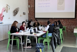 Eight postgraduate research students sat around a large rectangle table with laptops at the writing retreat