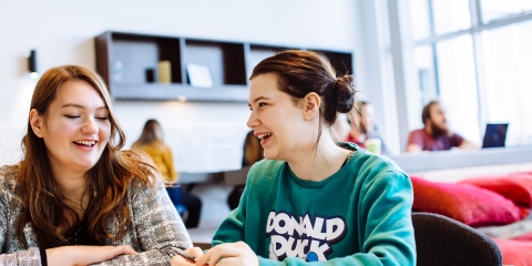 Male and female students studying in University library