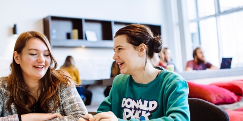 Male and female students studying in University library