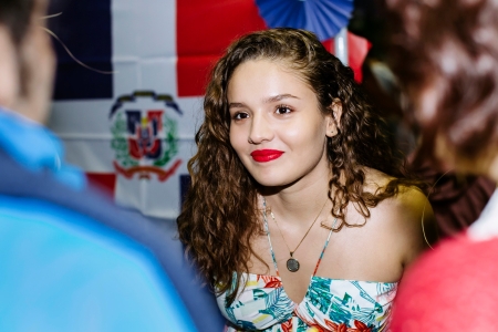 Female student smiling and talking to others at Festival of Cultures