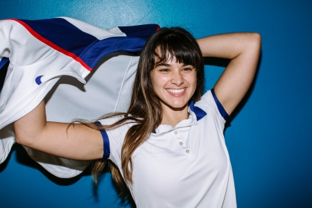 Smiling student ready for Clearing as she puts on her sports jacket.