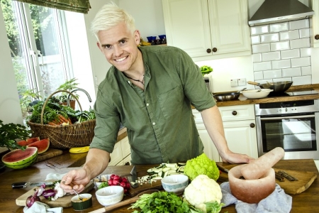 Mitch in his kitchen surrounded by vegetables