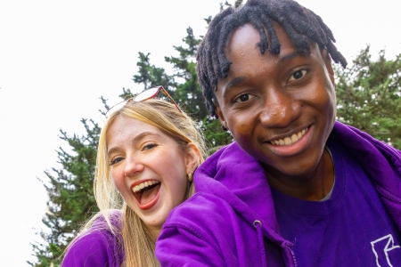 2 ambassadors smiling at camera outside in Ravelin Park. 