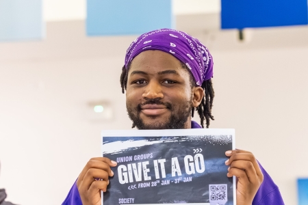 Student holding a sign saying give it a go