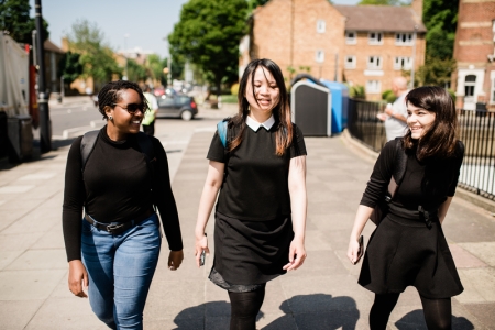 Smiling students walking down street in sun