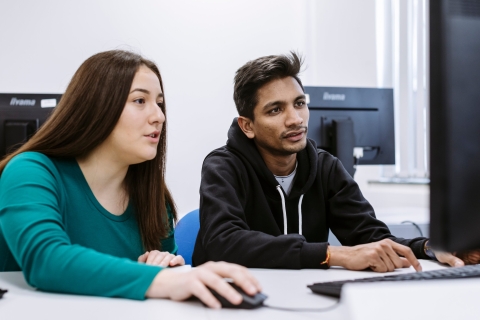 two students looking at a computer screen