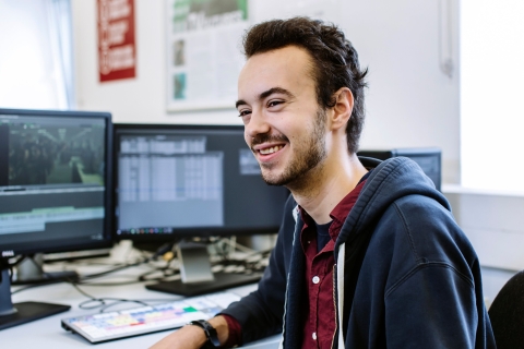 Smiling male student at computer