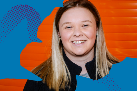 Student smiling and looking at the camera on a blue and orange background