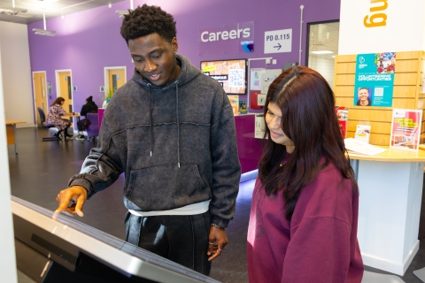 Two students using a touchscreen wayfinder