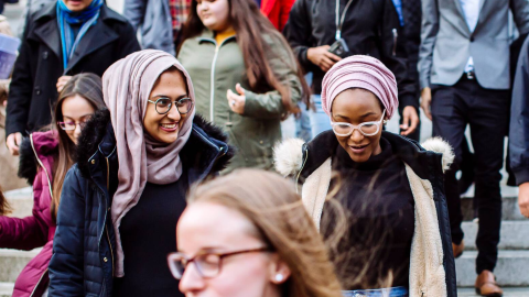 Two PGM students walking out of a university building deep in conversation