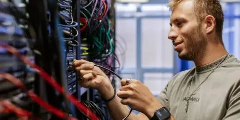 student unplugging various coloured cables
