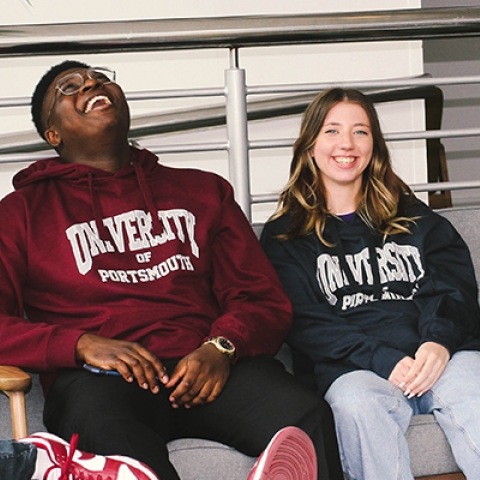 students sitting on soft chairs wearing university of portsmouth hoodies